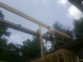 Carpenter setting a ridge beam over a new addition frame — Ice Dam Removal by Roofing Brothers in Curtis Bay