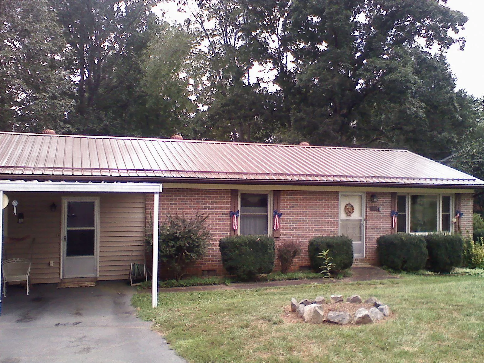 Bronze metal roof and carport on a brick ranch home — Roof Repair work by our crew in Curtis Bay