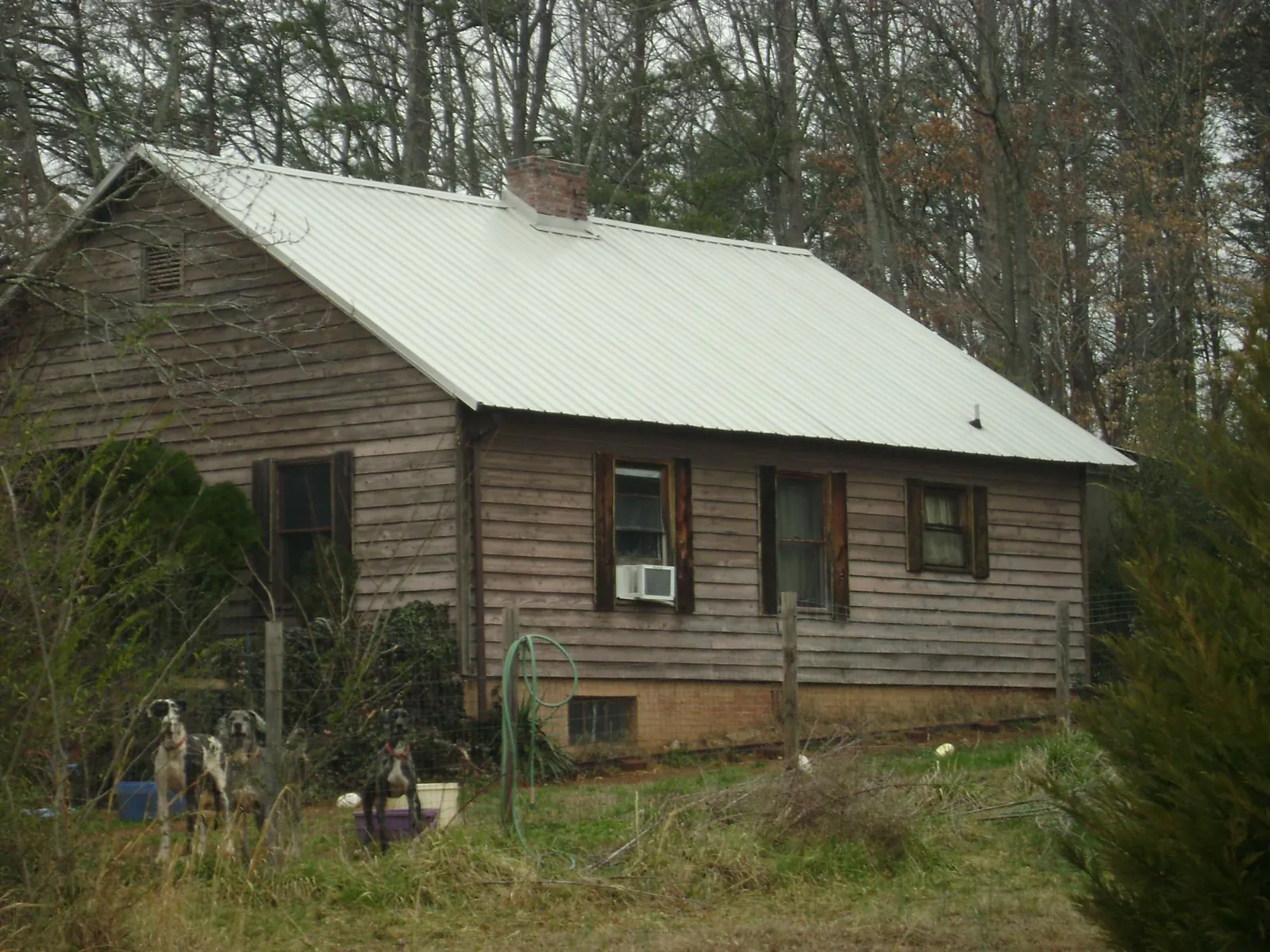 White metal roof on an old wood sided farmhouse, from a Metal Roof Installation job in Curtis Bay